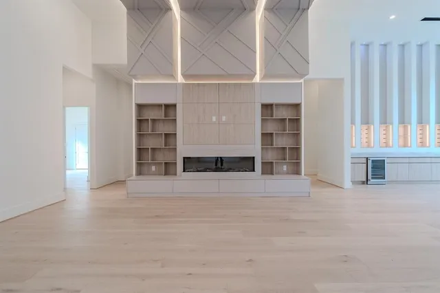 a view of an empty room with a window and cabinet