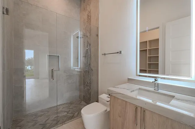 a bathroom with a granite countertop sink toilet and shower