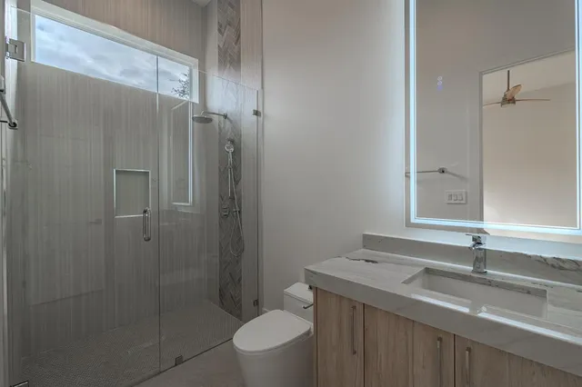 a bathroom with a granite countertop sink toilet and shower