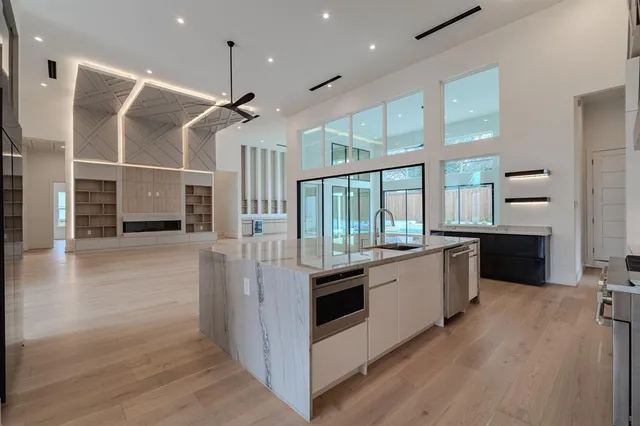 a large kitchen with kitchen island a large counter space a sink appliances and cabinets