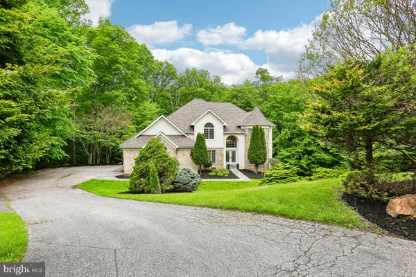 a aerial view of a house with garden and tall trees