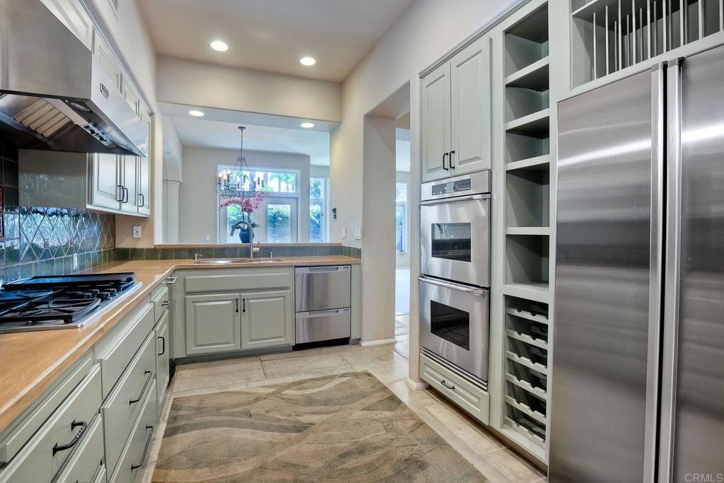 15333 Via Simpatico Rancho Santa Fe, CA 92091 - Photo 1 of 1 a kitchen with stainless steel appliances kitchen island granite countertop a refrigerator and a stove top oven