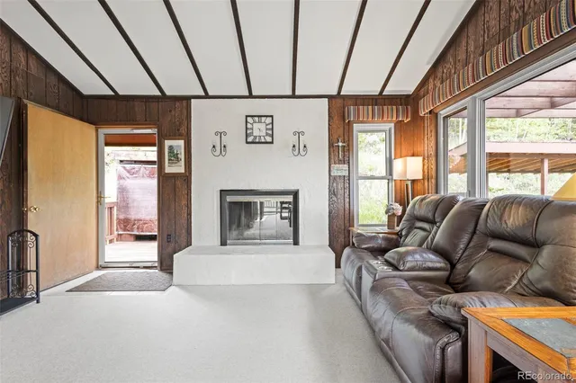 a living room with furniture a fireplace and a large window