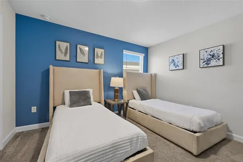 a bedroom with two beds and a night stand