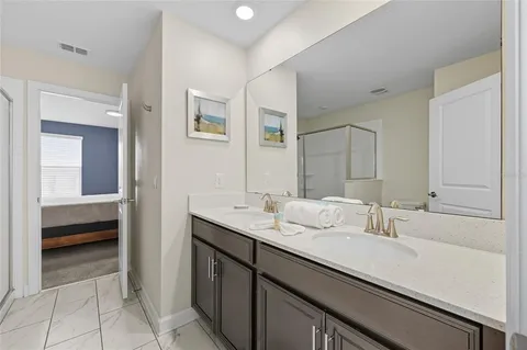 a en suite bathroom with a double vanity sink and a mirror