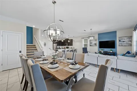 a view of a dining room with furniture a chandelier and wooden floor