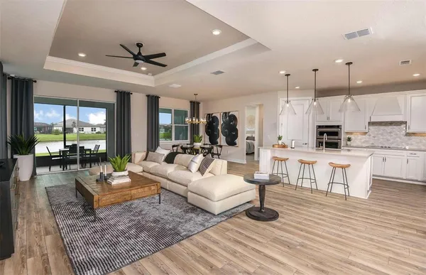 a living room with lots of furniture and kitchen view