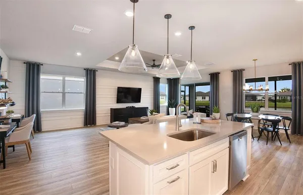 a view of a kitchen and dining room with wooden floor windows a chandelier