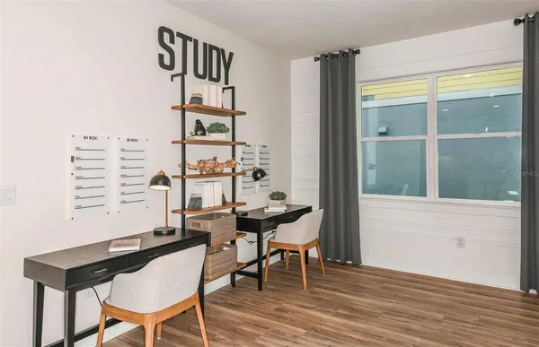 a view of a workspace with furniture and a window