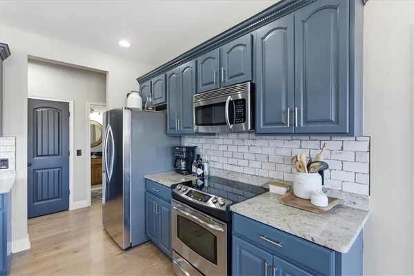 a spacious bedroom with a bed a flat screen tv and a window