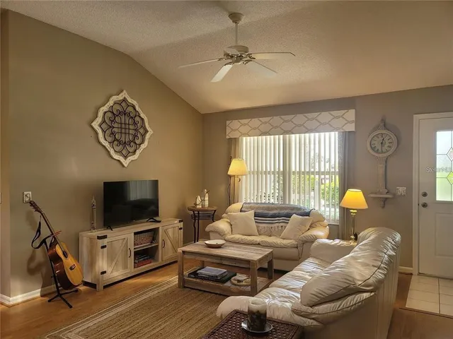 a living room with furniture a flat screen tv and a window