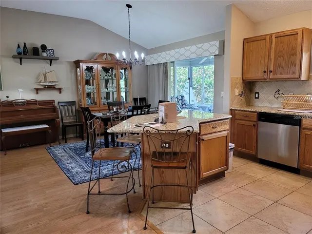 a kitchen with a stove a sink a dining table and chairs