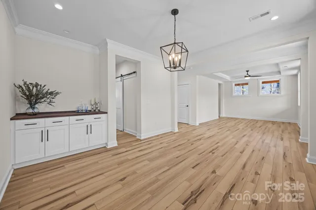 a view of empty room with wooden floor and window