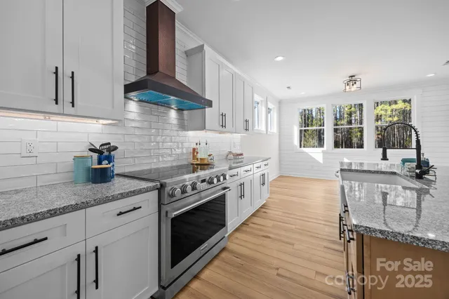 a kitchen with stainless steel appliances granite countertop a stove and cabinets