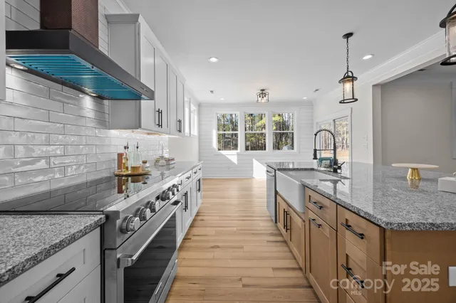 a kitchen with stainless steel appliances granite countertop a sink and stove