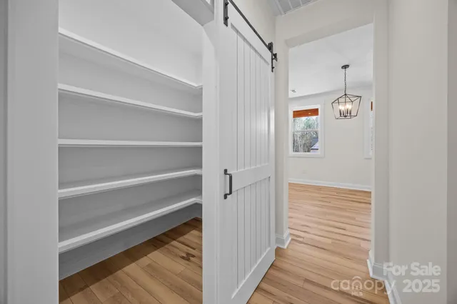 a bathroom with a walk in closet and wooden floor