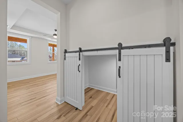 a view of hallway with wooden floor and window