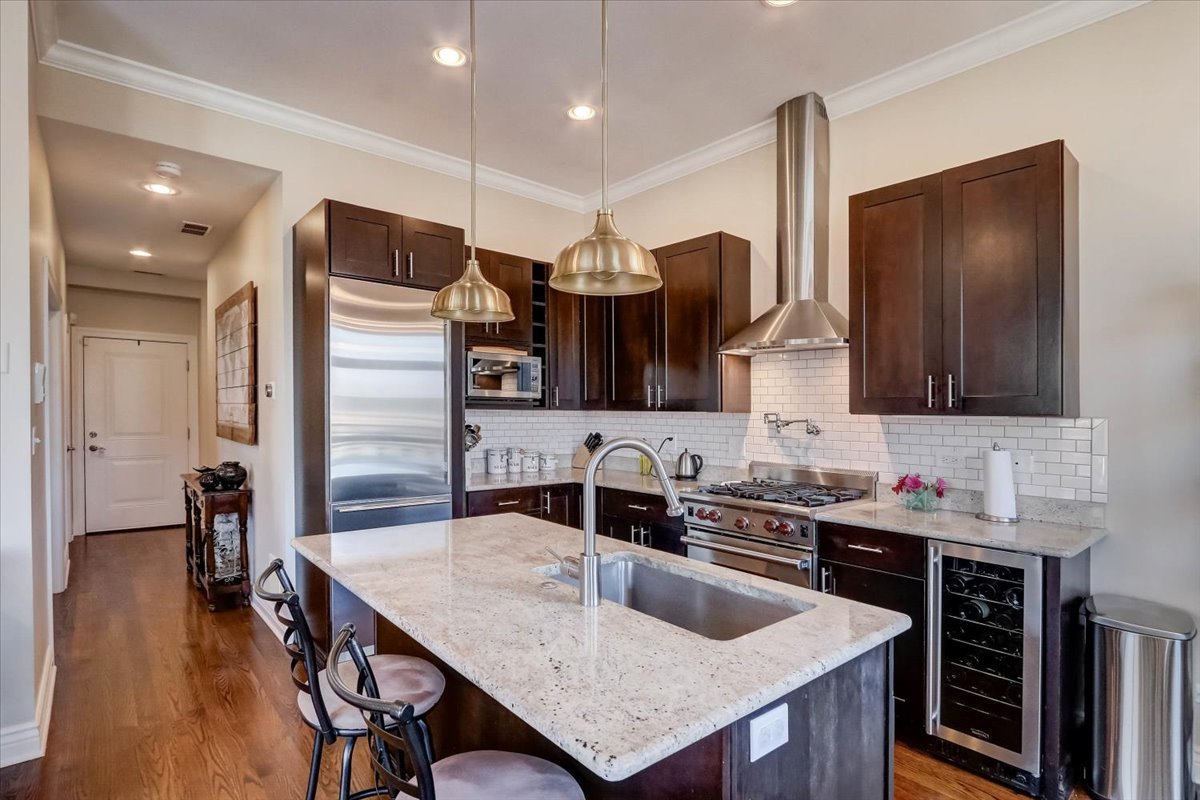 Undisclosed Address Chicago, IL 60657 - Photo 11 of 23 a kitchen with kitchen island a sink stove and refrigerator