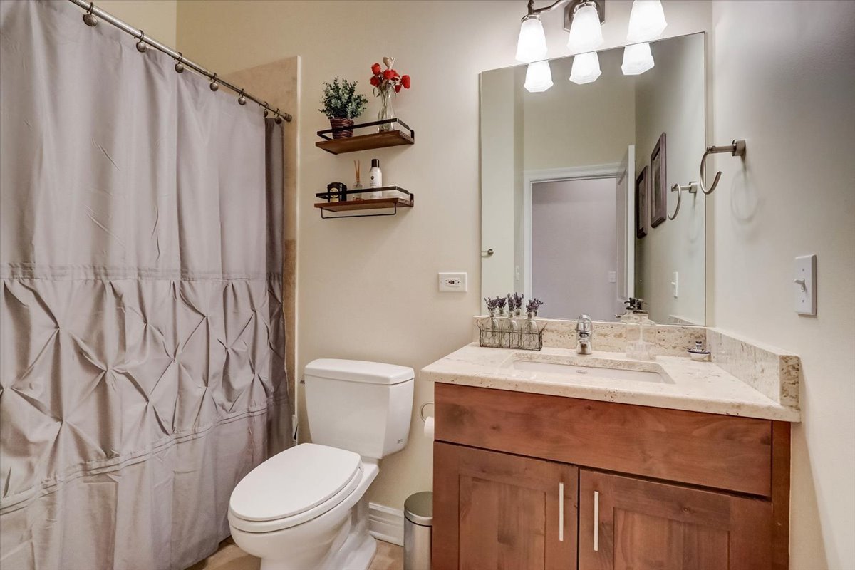 Undisclosed Address Chicago, IL 60657 - Photo 15 of 23 a bathroom with a sink a toilet and shower curtain