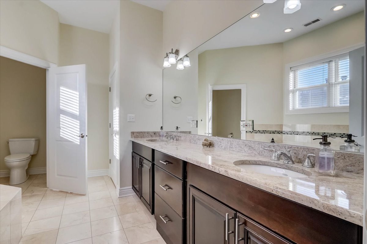 Undisclosed Address Chicago, IL 60657 - Photo 18 of 23 a spacious bathroom with a granite countertop double vanity sink a mirror and a toilet