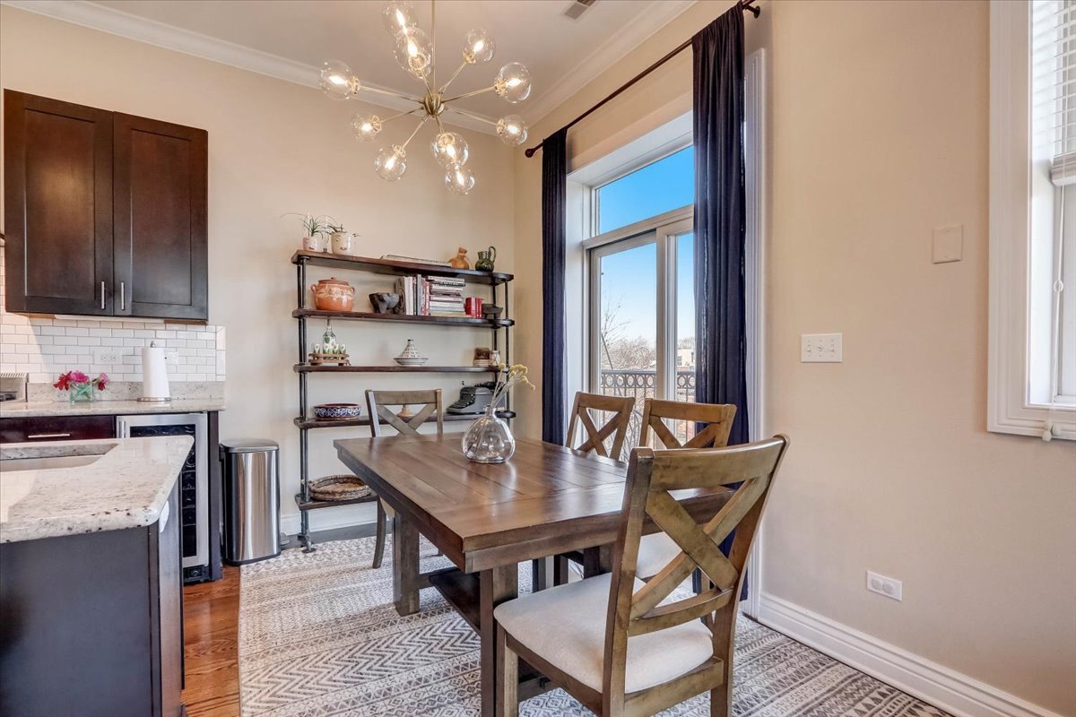 Undisclosed Address Chicago, IL 60657 - Photo 6 of 23 a kitchen with a table chairs refrigerator and cabinets