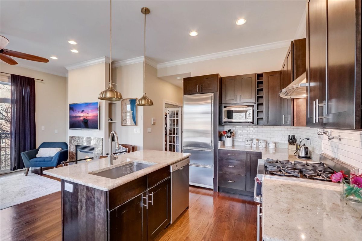 Undisclosed Address Chicago, IL 60657 - Photo 8 of 23 a kitchen with kitchen island granite countertop a sink and refrigerator