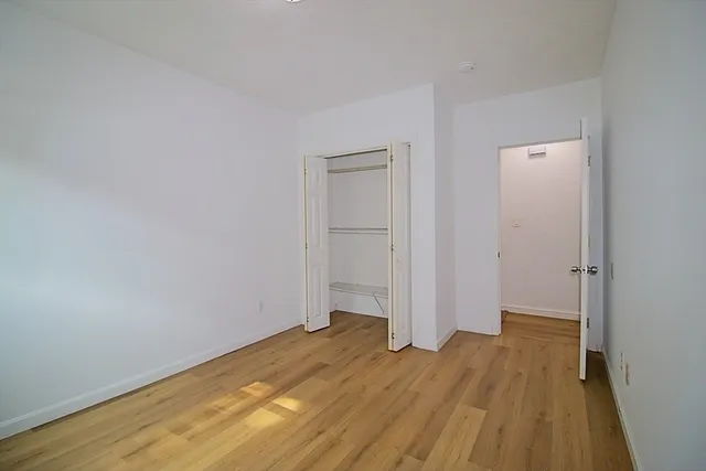 an empty room with wooden floor and closet