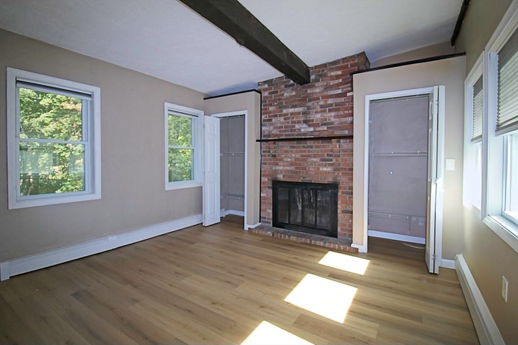 45 Depot Street, Unit 1 Sharon, MA 02067 - Photo 9 of 12 a view of empty room with wooden floor and fireplace