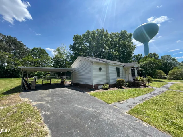 a view of a house with backyard and sitting area
