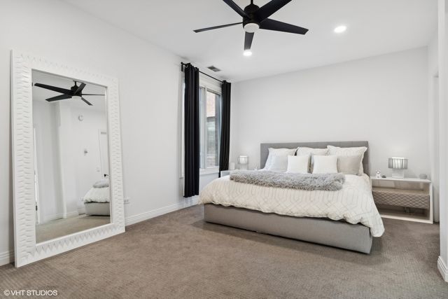 a spacious bedroom with a bed and a chandelier