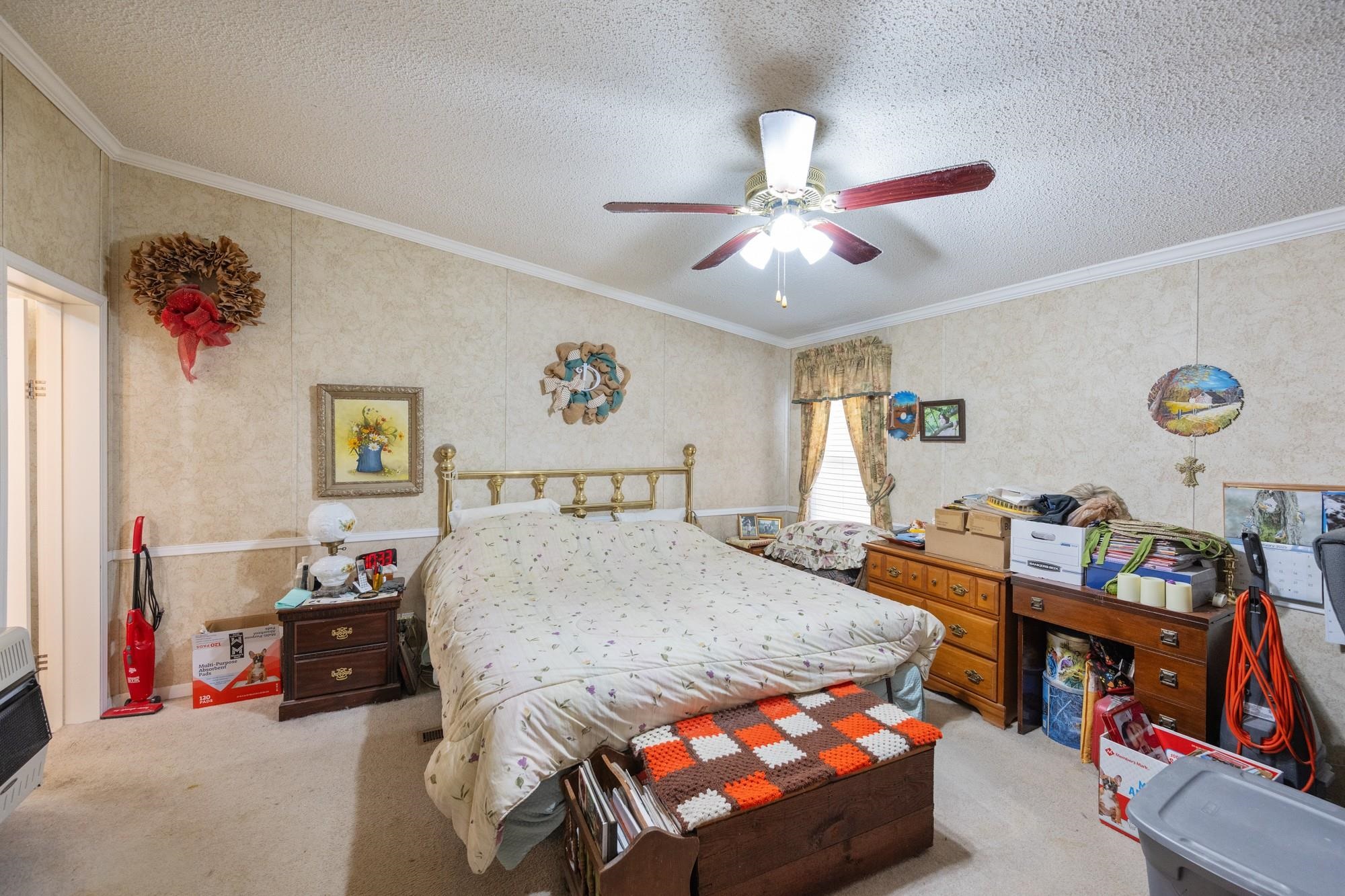 416 Haney School Road Decaturville, TN 38329 - Photo 14 of 35 a bedroom with a bed and a chandelier