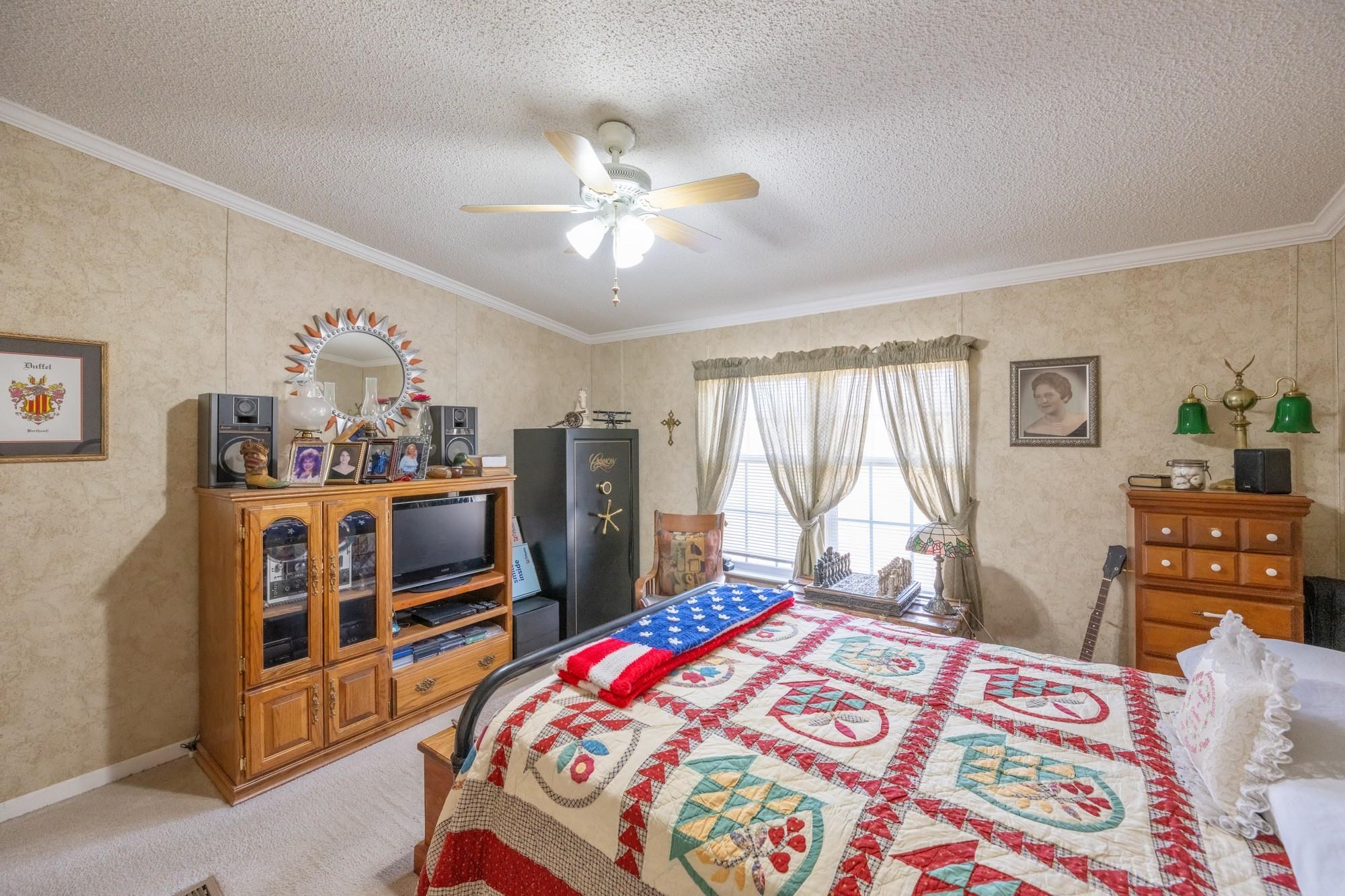 416 Haney School Road Decaturville, TN 38329 - Photo 18 of 35 a bedroom with a bed a dresser and a chandelier