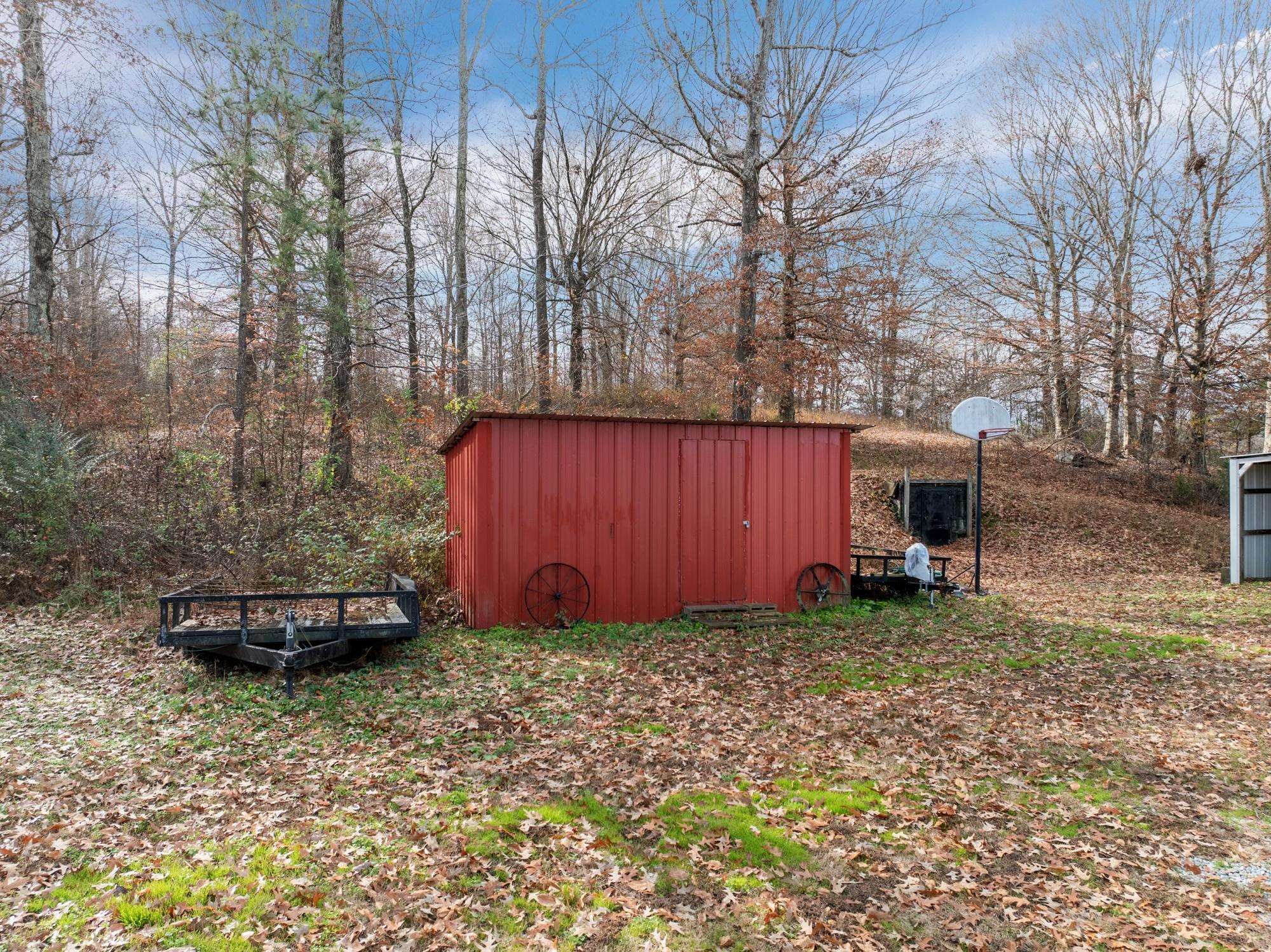 416 Haney School Road Decaturville, TN 38329 - Photo 25 of 35 a view of a backyard with large trees and a small barn