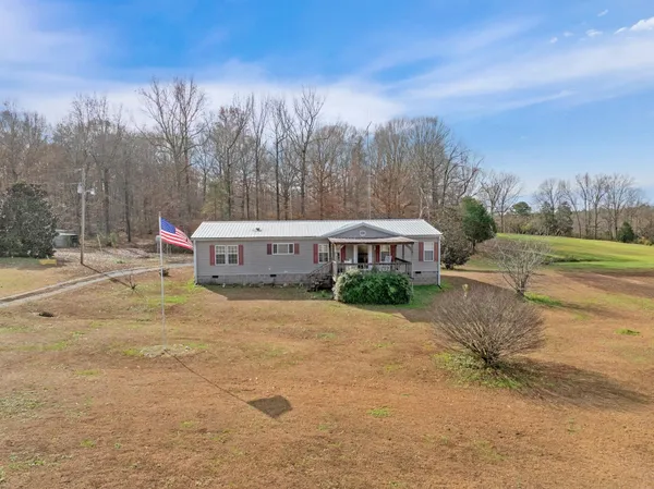 a front view of a house with a yard and trees