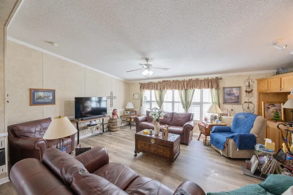a living room with furniture flat screen tv and large window