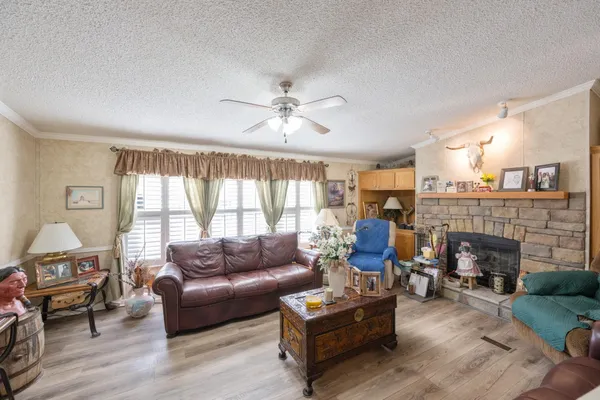 a living room with furniture a fireplace and a large window