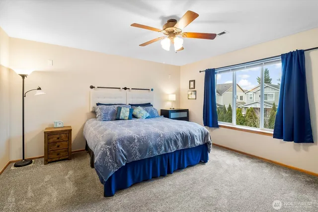 a bedroom with a large bed and a chandelier fan