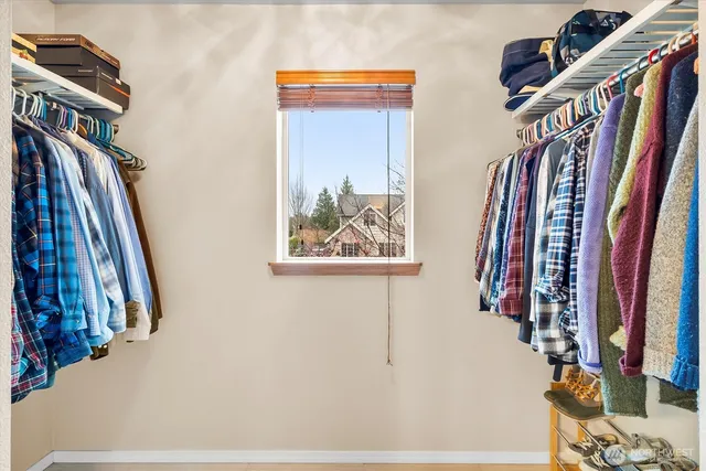 a view of walk in closet with clothes and shoes