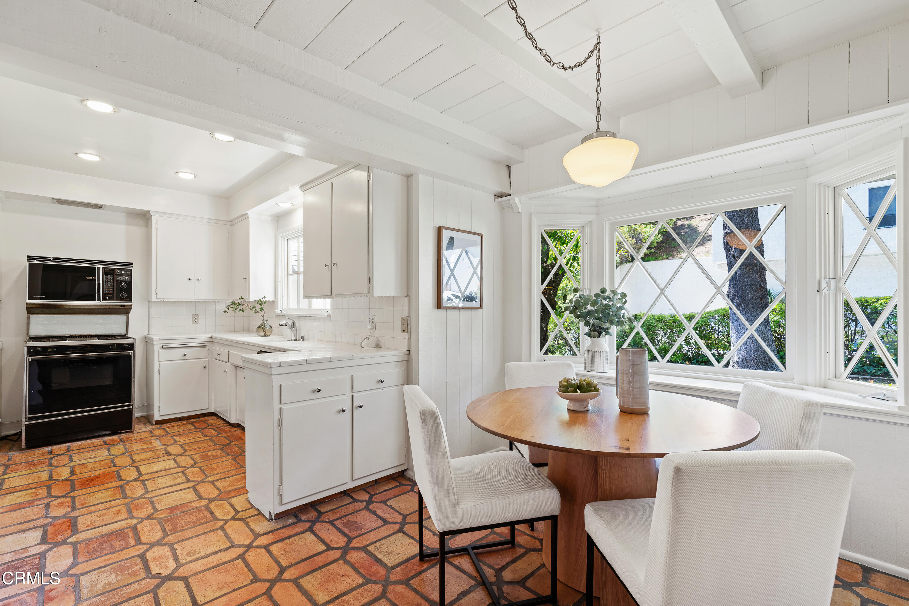 2040 Roscomare Road Los Angeles, CA 90077 - Photo 8 of 30 a kitchen with a dining table cabinets and appliances
