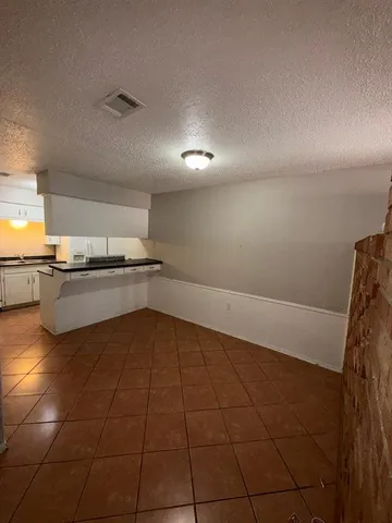 a kitchen with granite countertop stainless steel appliances a stove a sink and a refrigerator