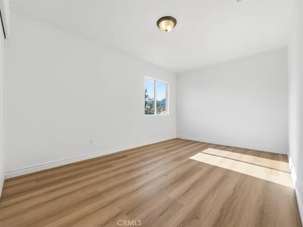 a view of an empty room with wooden floor