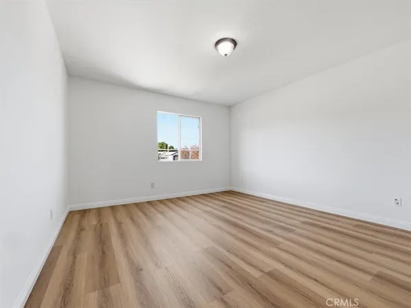 a view of empty room with wooden floor and fireplace