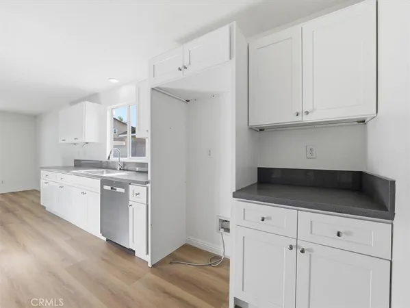 a large kitchen with cabinets wooden floor and stainless steel appliances