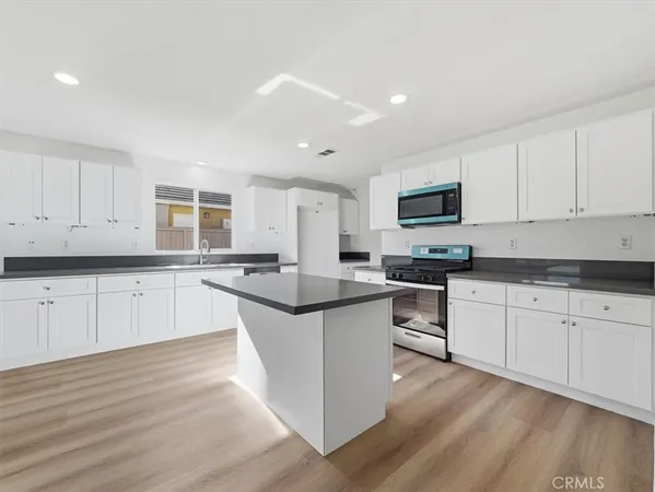 a kitchen with granite countertop white cabinets and a sink