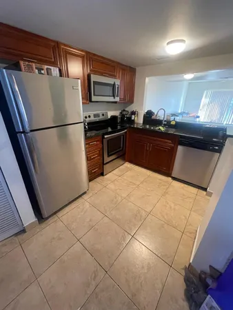 a kitchen with stainless steel appliances granite countertop a refrigerator a stove a sink and a microwave