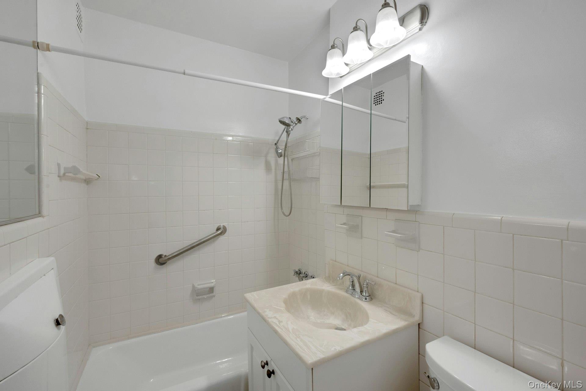 260 Garth Road, Unit 4E4 Scarsdale, NY 10583 - Photo 22 of 29 Full bathroom with vanity, shower / bathtub combination, and tile walls
