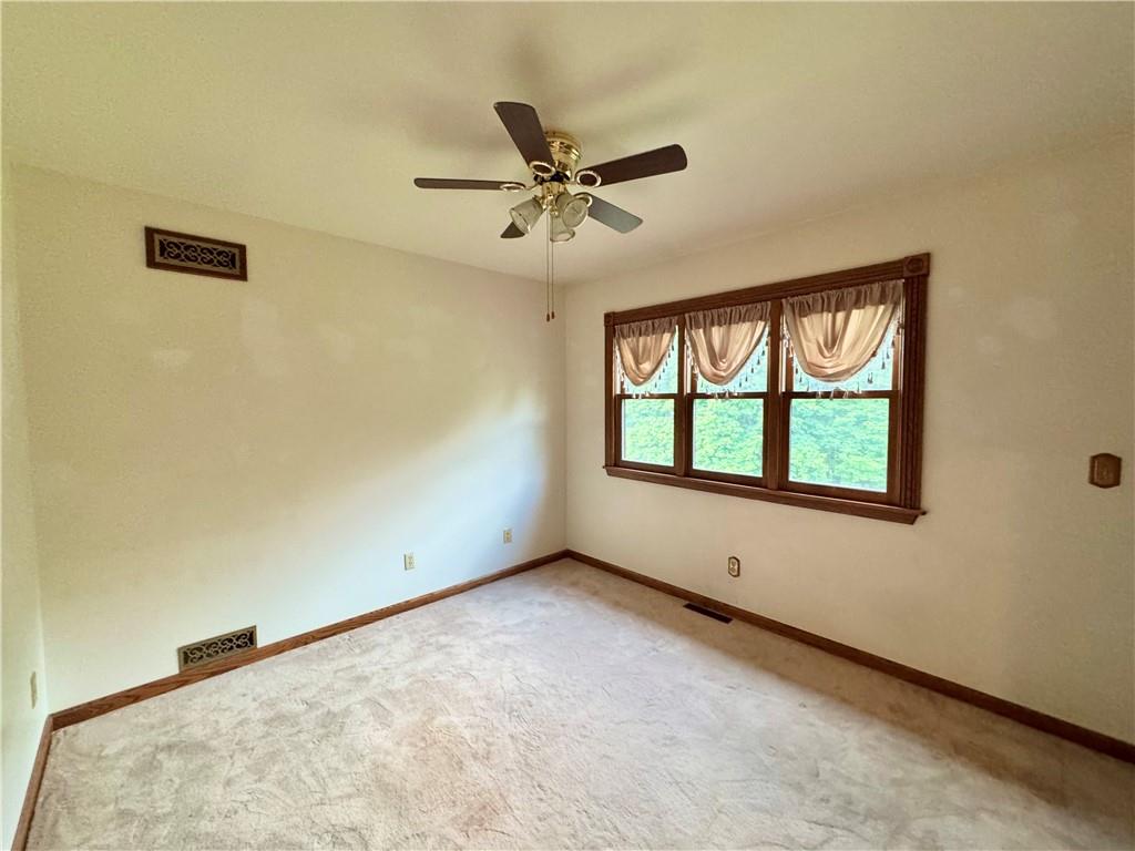 796 Hoover Road New Castle, PA 16101 - Photo 34 of 43 an empty room with windows and ceiling fan view