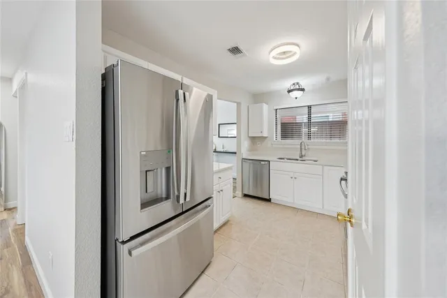 a kitchen with white cabinets and white appliances