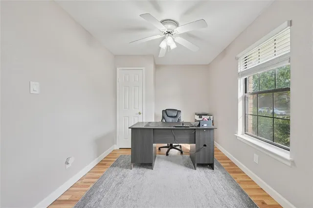 a view of workspace with a window and wooden floor