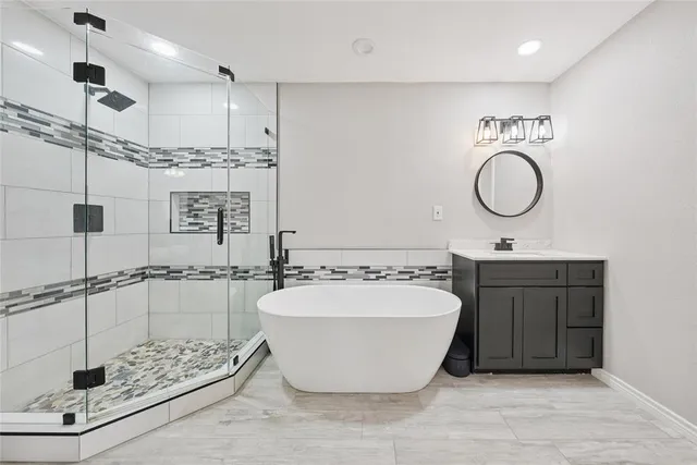 a spacious bathroom with a tub sink and mirror